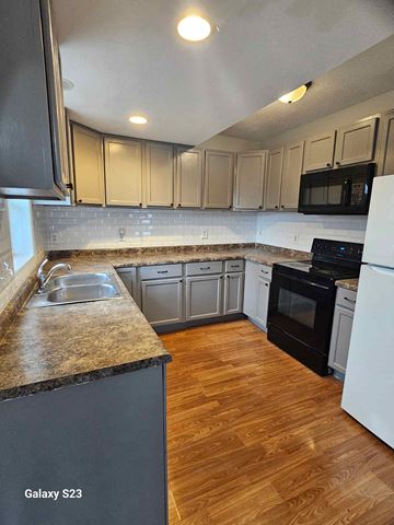 Saint Paul apartment for rent - A kitchen with a black granite countertop and white appliances.