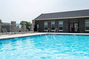 Waukee apartment for rent - a swimming pool in front of a brick building