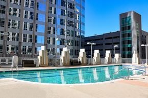 Charlotte apartment for rent - A large swimming pool in front of a tall building.