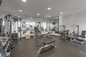 Charlotte apartment for rent - A spacious gym with a variety of equipment including treadmills, weights, and benches.