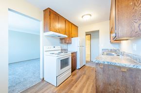 St. Paul apartment for rent - an empty kitchen with white appliances and wooden cabinets