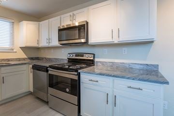 Denver apartment for rent - A kitchen with white cabinets and a granite countertop.
