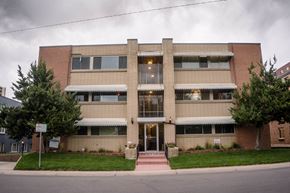 Denver apartment for rent - A building with a red brick facade and a white awning.
