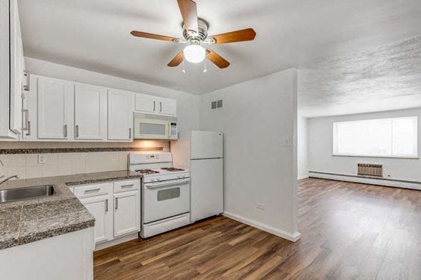 Denver apartment for rent - A kitchen with white cabinets and a wood floor.