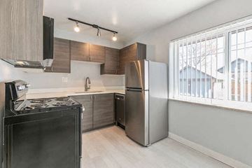 Denver apartment for rent - A modern kitchen with a black stove top oven and a silver refrigerator.