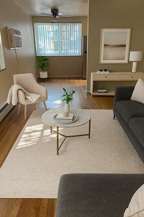 Denver apartment for rent - A living room with a grey couch, a white chair, and a coffee table.
