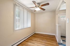 Denver apartment for rent - A room with a ceiling fan and a window with white curtains.