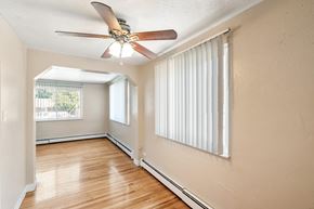 Denver apartment for rent - A room with a ceiling fan and a window with blinds.