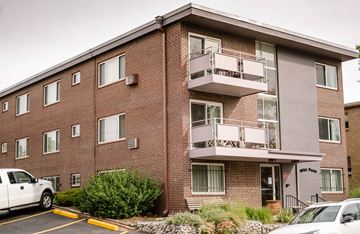Denver apartment for rent - a brick apartment building with two balconies and a parking lot