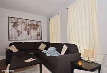 Chicago apartment for rent - a living room with a brown couch and a painting on the wall