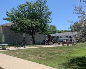 Albert Lea apartment for rent - a playground in front of a building with a tree