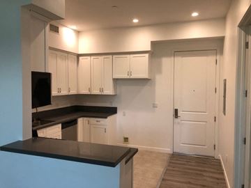 Van Nuys apartment for rent - a kitchen with white cabinets and a black counter top