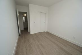 Edmonton apartment for rent - a bedroom with white walls and wood flooring and a closet