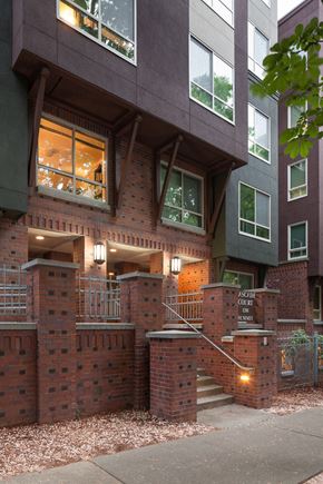 Seattle apartment for rent - a view of the front of a brick building with windows and a staircase