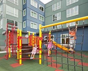 Seattle apartment for rent - Children playing on a playground with a red and yellow structure.