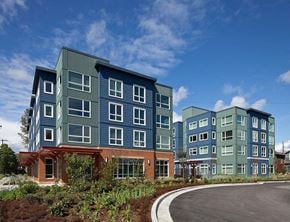Seattle apartment for rent - A modern building with a red brick base and blue panels on the upper floors.
