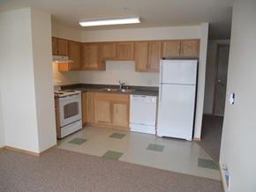 Seattle apartment for rent - A kitchen with white appliances and wooden cabinets.