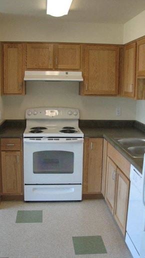 Seattle apartment for rent - A white stove and oven in a kitchen with wooden cabinets.