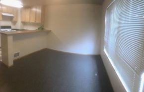 Seattle apartment for rent - an empty room with a window and a kitchen