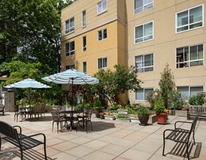 Seattle apartment for rent - a patio with tables and umbrellas in front of a building