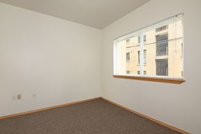 Seattle apartment for rent - a bedroom with a large window and a carpeted floor