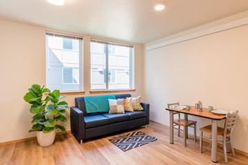 Seattle apartment for rent - A living room with a black couch and a wooden table.