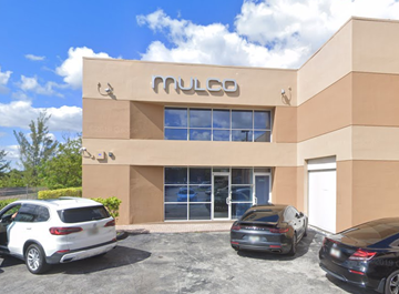 Miami apartment for rent - A building with the word "PULCO" on it has cars parked in front.