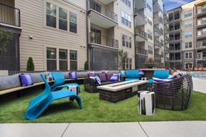 Atlanta apartment for rent - an outdoor lounge area with couches and tables in front of an apartment building