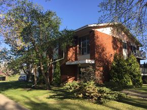 Edmonton apartment for rent - a red brick house with trees in front of it