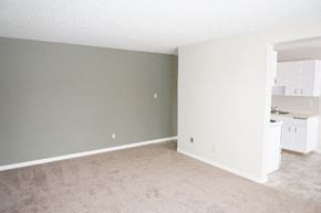 Edmonton apartment for rent - an empty living room and a kitchen with white cabinets