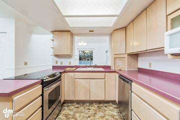 Anchorage house for rent - a kitchen with pink counter tops and wooden cabinets