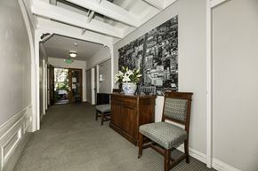 San Francisco apartment for rent - A hallway with a chair and a cabinet with a vase of flowers on top.