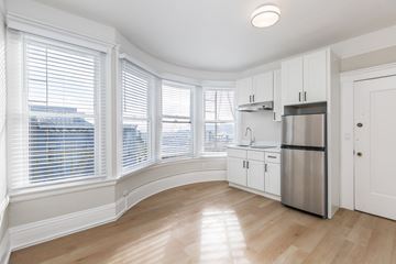 San Francisco apartment for rent - A kitchen with white cabinets and a stainless steel refrigerator.