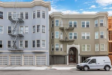 San Francisco apartment for rent - A white van is parked in front of a tan building.