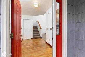 Anchorage house for rent - a renovated living room with a red door and a staircase