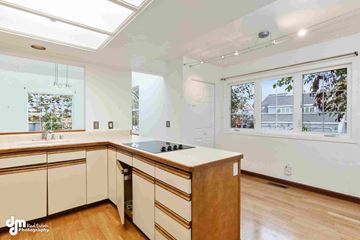Anchorage house for rent - an updated kitchen with white cabinets and a large window