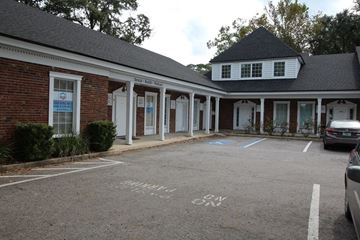 Jacksonville apartment for rent - A parking lot with a building in the background and a car parked in the lot.