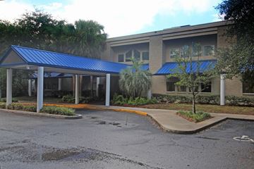 Jacksonville apartment for rent - A building with a blue roof and a parking lot in front.