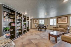 Eagle apartment for rent - Image of book shelves with books, couches, coffee table, and kitchen table with chairs along with windows