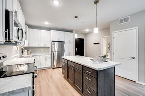 Bloomington apartment for rent - an expansive kitchen with white cabinets and stainless steel appliances