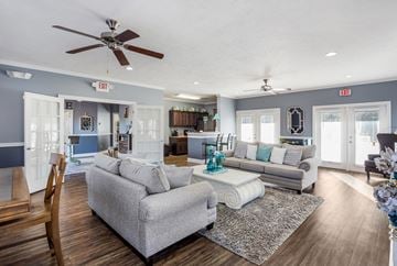 Hattiesburg apartment for rent - A living room with a grey couch and a wooden chair.