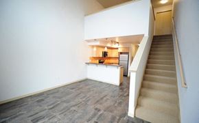 Seattle apartment for rent - an empty living room with a staircase and a kitchen