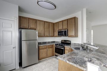 Reisterstown townhouse for rent - a kitchen with stainless steel appliances and granite counter tops