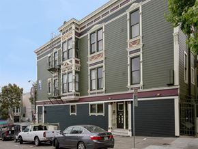 San Francisco apartment for rent - a green and gray building with cars parked in front of it