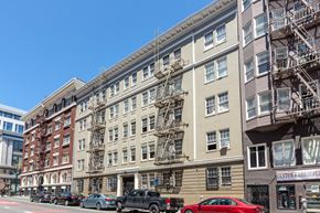 San Francisco apartment for rent - a large apartment building on a city street with cars parked in front