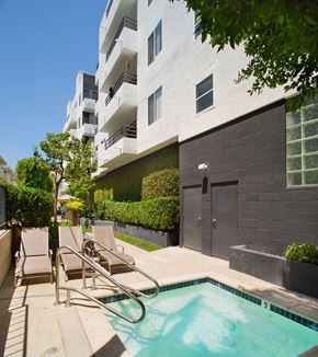 Los Angeles apartment for rent - a swimming pool with chairs in front of an apartment building