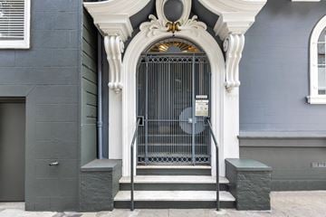 San Francisco apartment for rent - A grey building with a white door and a fan on the wall.