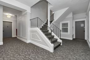 San Francisco apartment for rent - A hallway with a staircase and a patterned carpet.