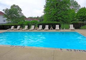 Portage apartment for rent - a large blue pool with white chairs