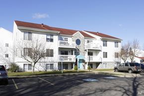 Portage apartment for rent - a parking lot in front of a white apartment building